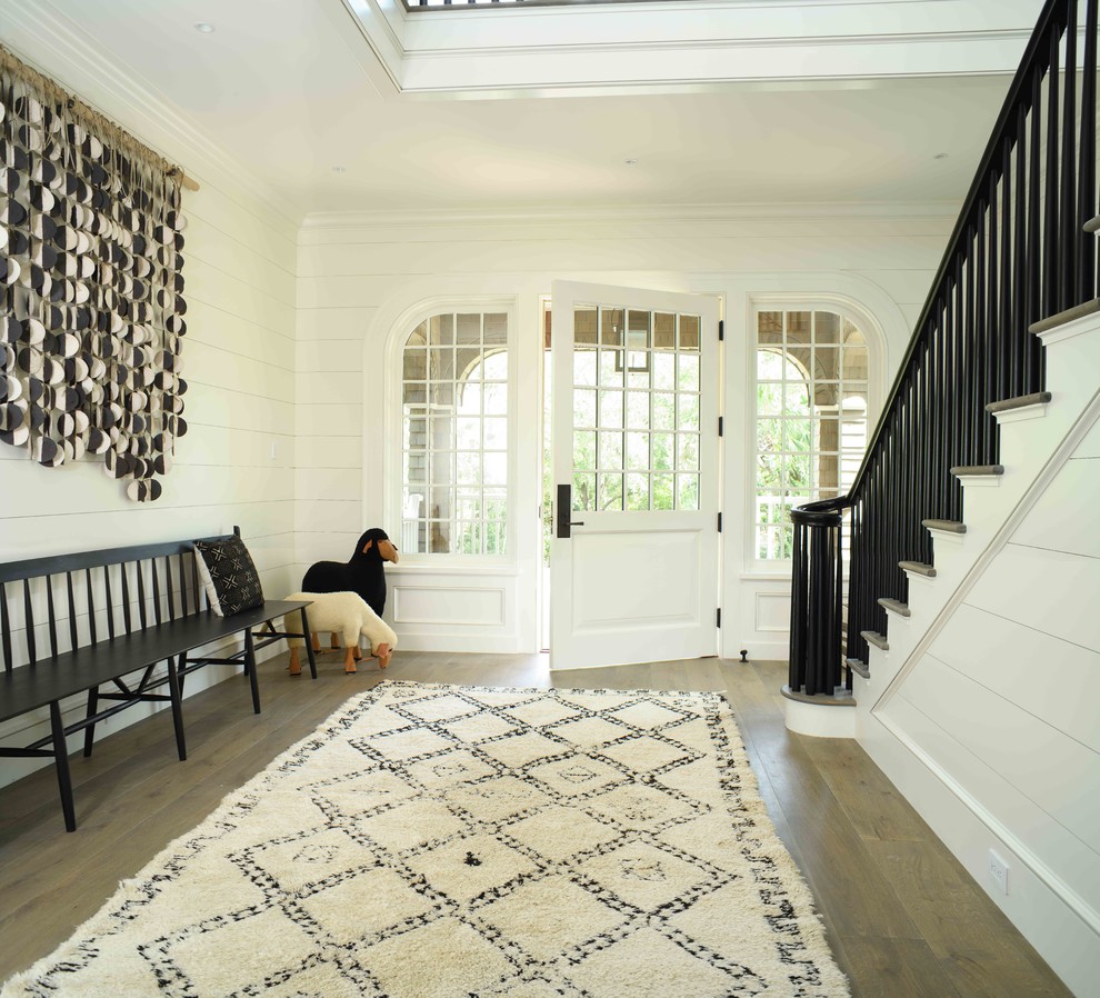 Maritimes Foyer mit weißer Wandfarbe, Einzeltür, weißer Haustür und dunklem Holzboden in Charleston