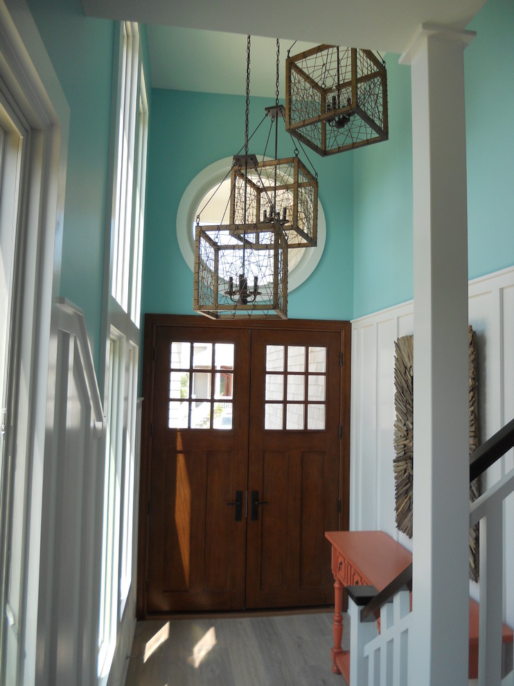 Foto di un ingresso stile marino di medie dimensioni con pareti blu, parquet chiaro, una porta a due ante, una porta in legno bruno e pavimento grigio