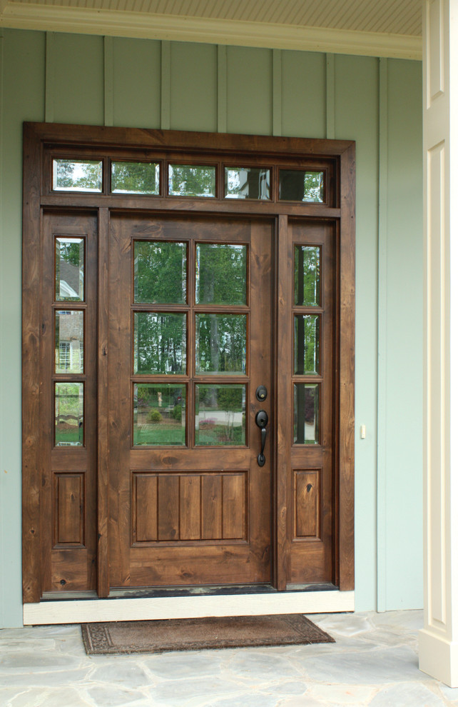 ローリーにあるカントリー風のおしゃれな玄関ドア (緑の壁、濃色木目調のドア) の写真