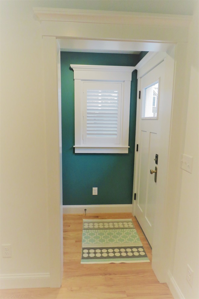 Ispirazione per un ingresso con anticamera stile marino di medie dimensioni con pareti verdi, parquet chiaro, una porta singola, una porta bianca e pavimento beige