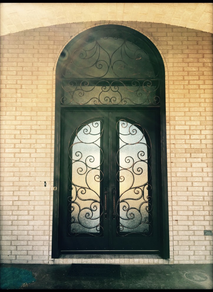 Modelo de puerta principal clásica de tamaño medio con paredes beige, suelo de ladrillo, puerta doble y puerta de vidrio
