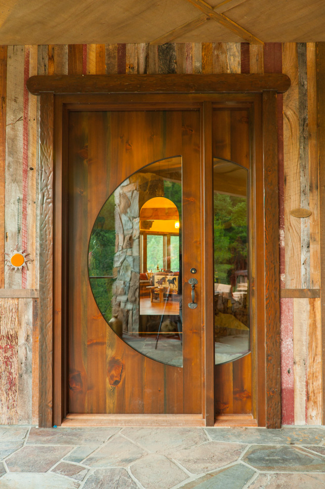 シアトルにある広いラスティックスタイルのおしゃれな玄関ドア (木目調のドア、茶色い壁、グレーの床) の写真