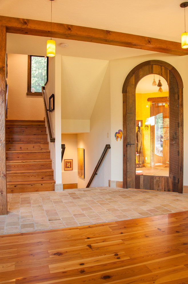 Idée de décoration pour une porte d'entrée chalet de taille moyenne avec un mur beige, parquet clair, un sol marron, une porte simple et une porte en bois brun.