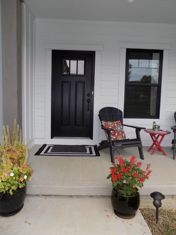 Inspiration for a large traditional entrance in Columbus with white walls, concrete flooring, a single front door, a black front door and grey floors.