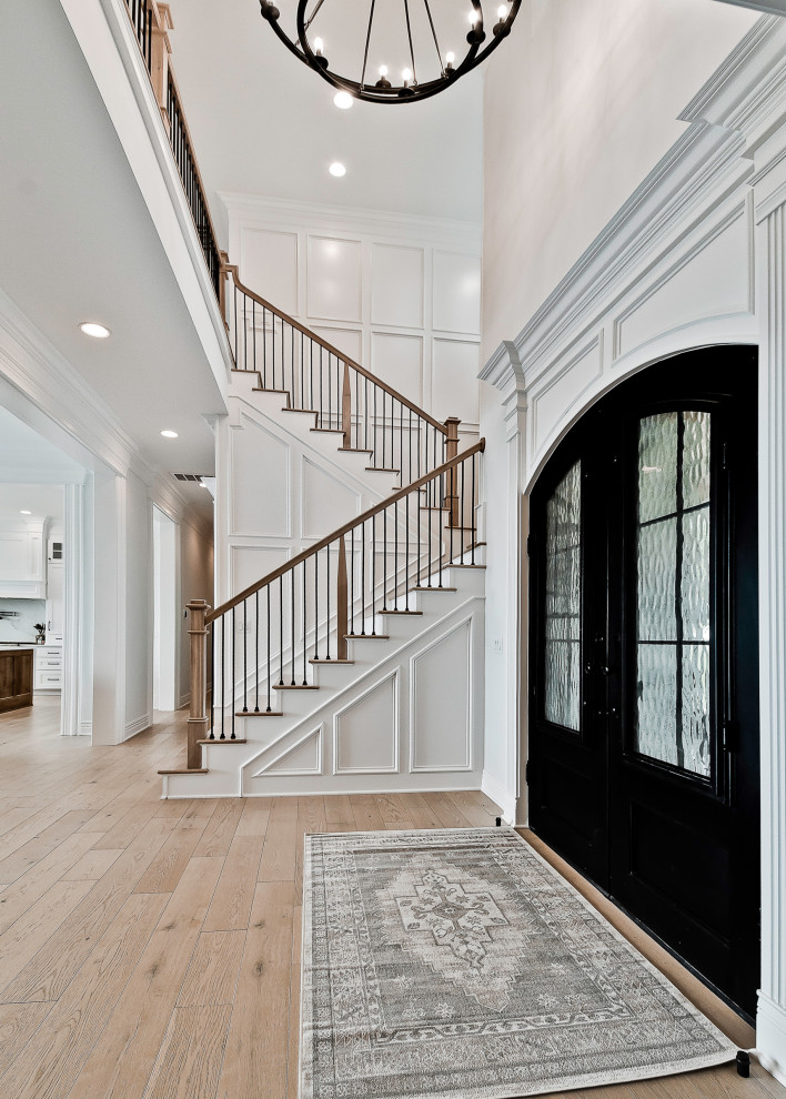 Diseño de puerta principal de estilo americano grande con paredes blancas, suelo de madera clara, puerta doble, puerta metalizada, suelo beige y madera