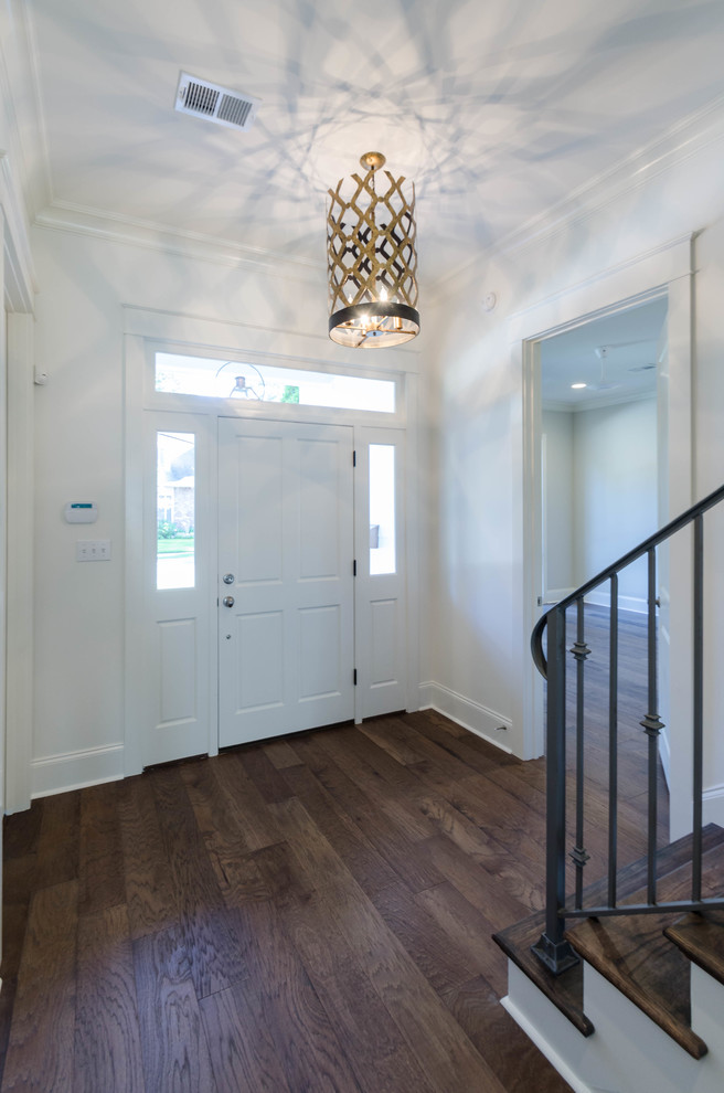 Inspiration for a large timeless medium tone wood floor entryway remodel in New Orleans with white walls and a white front door