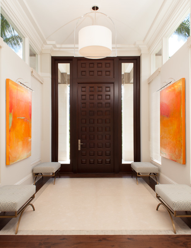 マイアミにある高級な巨大なトランジショナルスタイルのおしゃれな玄関ロビー (白い壁、ライムストーンの床、濃色木目調のドア) の写真
