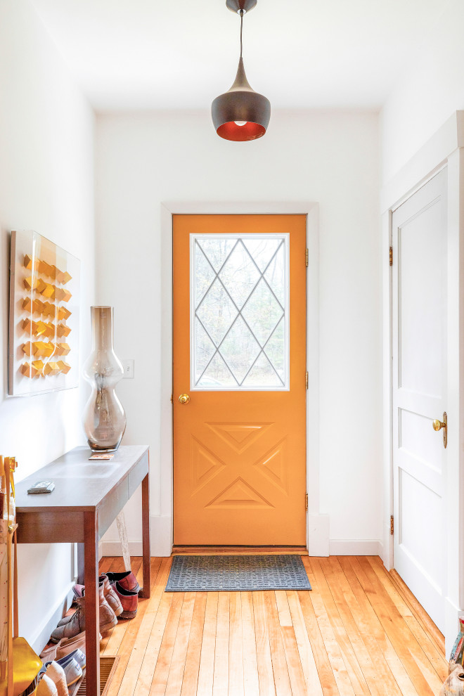 Réalisation d'une petite entrée vintage avec un vestiaire, un mur blanc, un sol en bois brun et une porte jaune.
