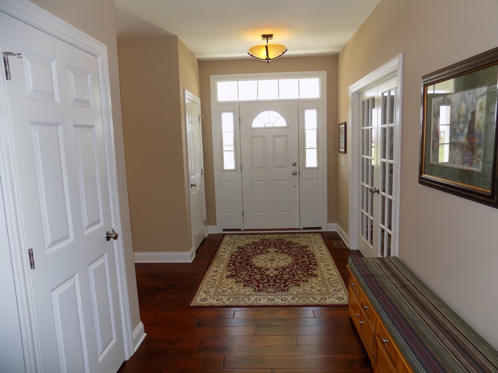 Entryway - mid-sized contemporary medium tone wood floor entryway idea in Columbus with beige walls and a white front door