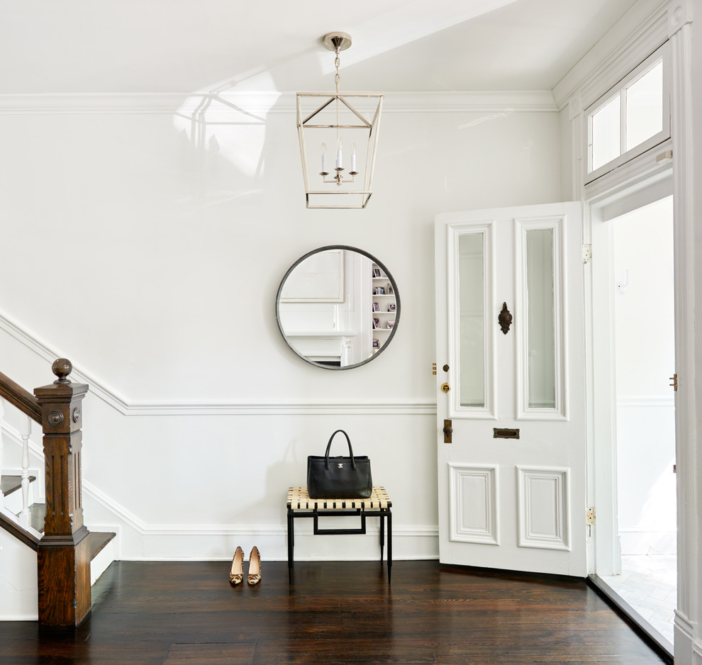 Immagine di un ingresso o corridoio chic con pareti bianche, parquet scuro, una porta singola e una porta bianca