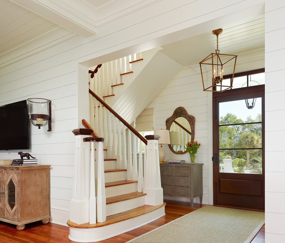 Island style medium tone wood floor entryway photo in Charleston with white walls and a glass front door