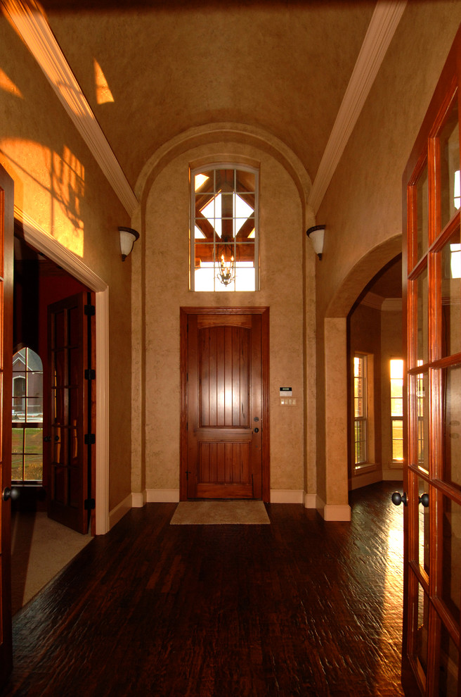ダラスにある中くらいなトラディショナルスタイルのおしゃれな玄関ドア (ベージュの壁、濃色無垢フローリング、木目調のドア、茶色い床) の写真