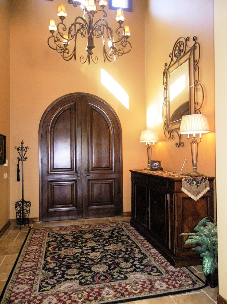 Inspiration pour une grande porte d'entrée traditionnelle avec un mur beige, un sol en travertin, une porte double et une porte en bois foncé.