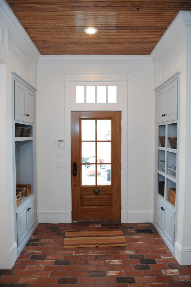 This is an example of a medium sized rural boot room in Other with brick flooring, a single front door and a light wood front door.