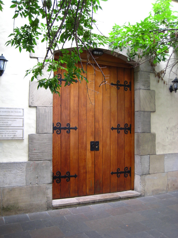 Idée de décoration pour une grande porte d'entrée vintage avec un mur beige, un sol en brique, une porte double et une porte en bois brun.