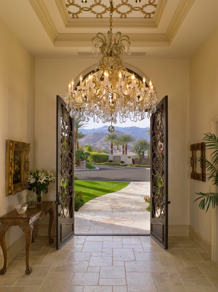 Example of a tuscan travertine floor entryway design in Los Angeles with a metal front door