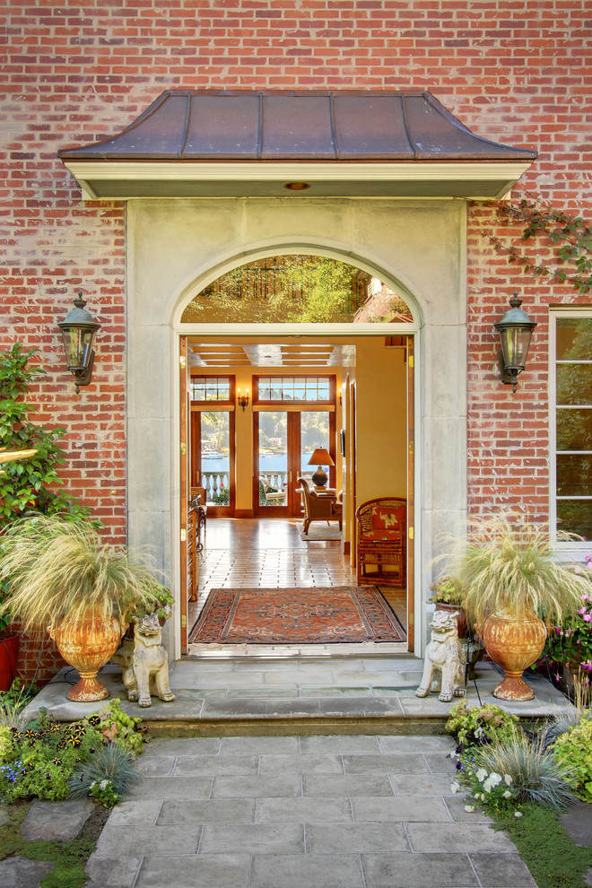 Источник вдохновения для домашнего уюта: входная дверь среднего размера в классическом стиле с двустворчатой входной дверью, красными стенами, бетонным полом, входной дверью из дерева среднего тона и серым полом