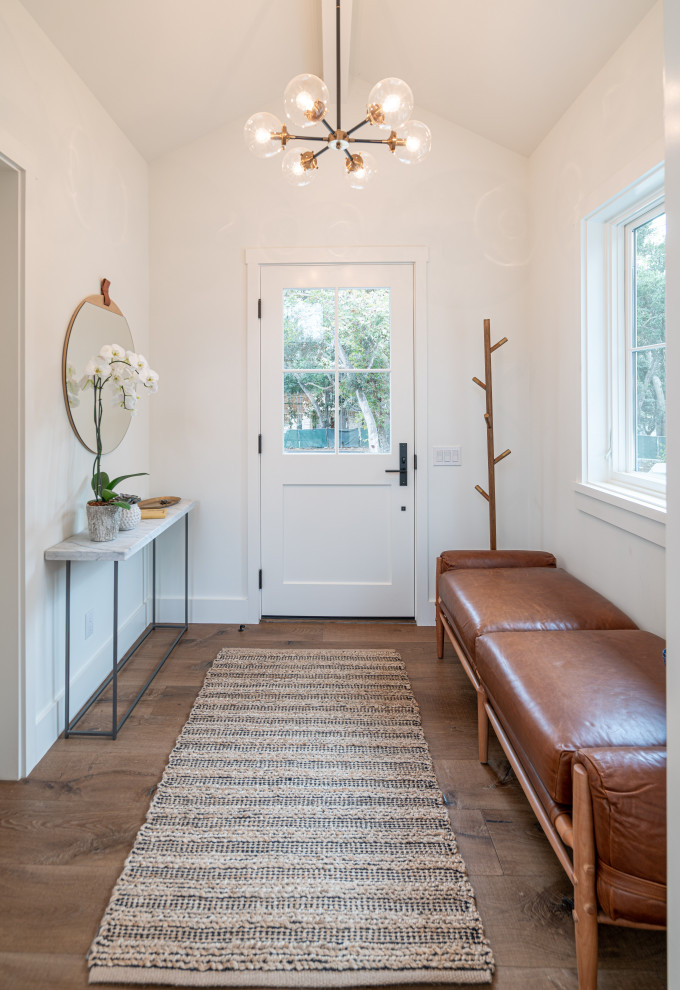 Modelo de hall clásico renovado de tamaño medio con paredes blancas, suelo de madera en tonos medios, suelo marrón, machihembrado, puerta simple y puerta blanca