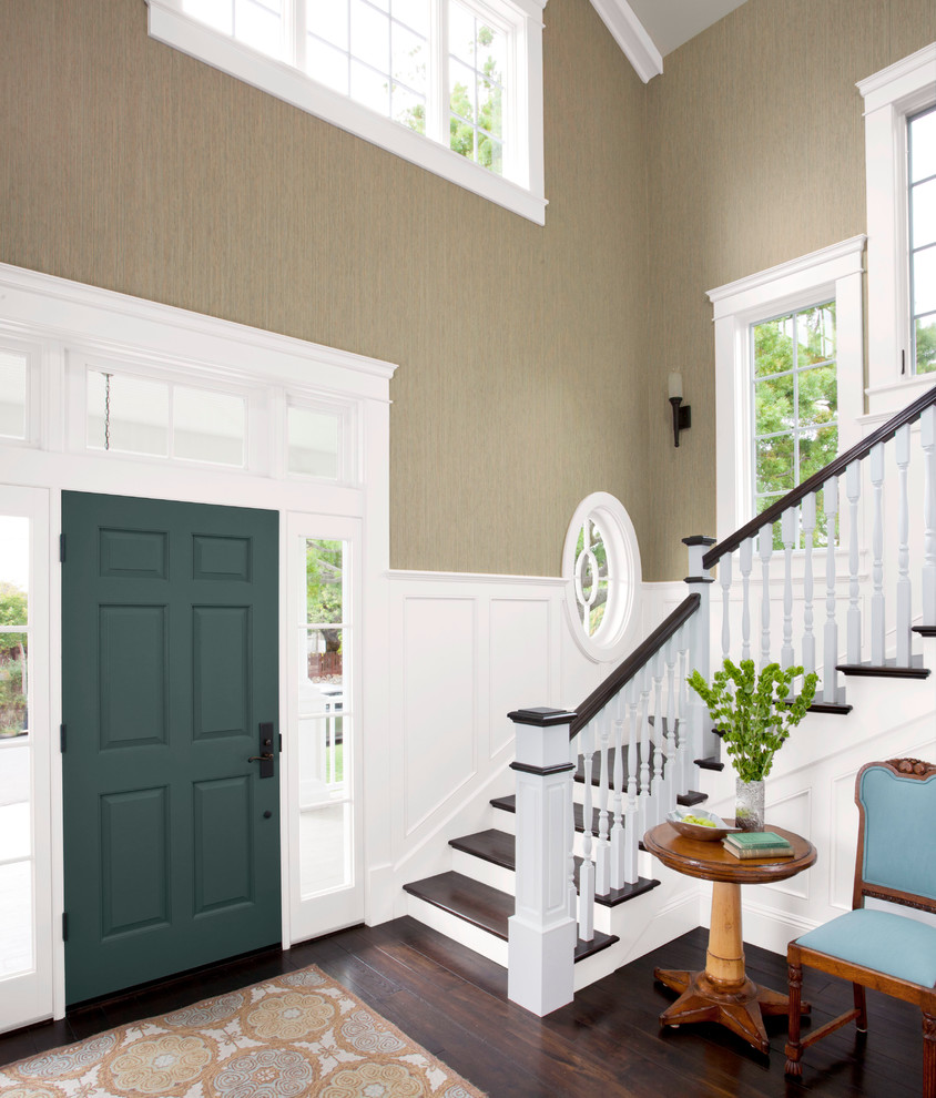 Cette image montre un grand hall d'entrée traditionnel avec un mur vert, parquet foncé, une porte simple et une porte verte.