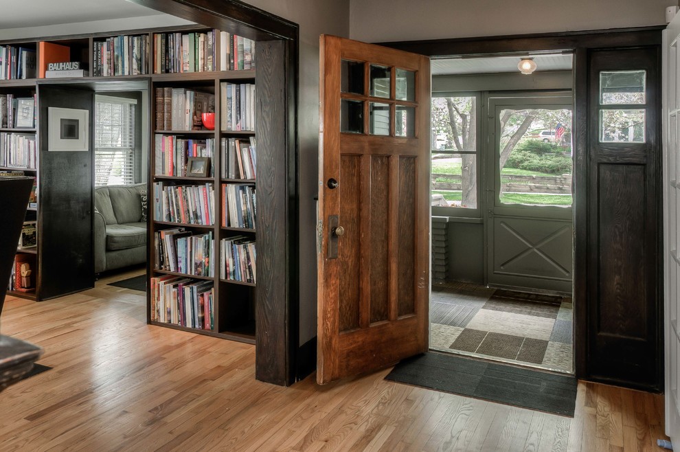 Inspiration pour un vestibule traditionnel de taille moyenne avec un mur gris, un sol en bois brun, une porte simple, une porte en bois foncé et un sol beige.