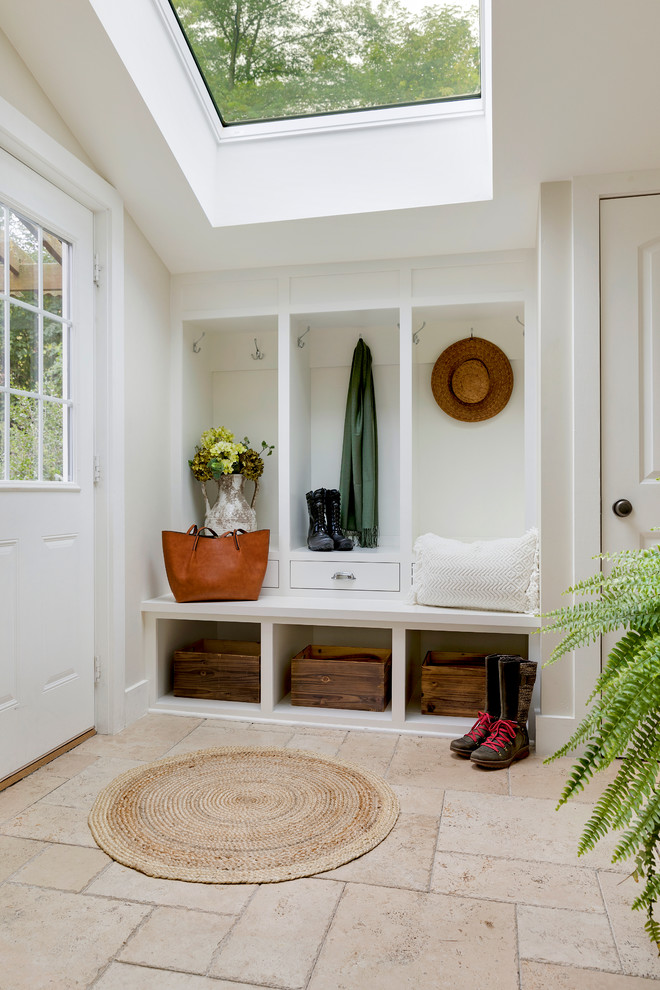 На фото: тамбур среднего размера в стиле кантри с белыми стенами, полом из травертина, одностворчатой входной дверью, белой входной дверью и коричневым полом