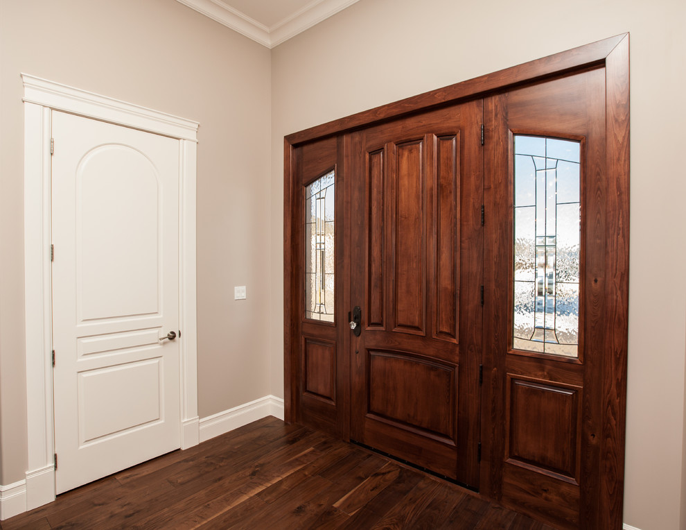 Пример оригинального дизайна: большая входная дверь в современном стиле с бежевыми стенами, паркетным полом среднего тона, поворотной входной дверью и входной дверью из дерева среднего тона