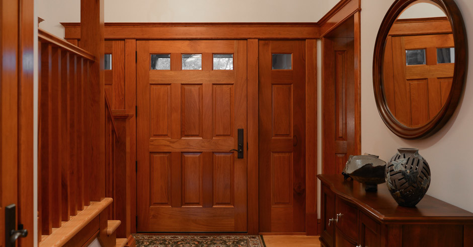 他の地域にある中くらいなトラディショナルスタイルのおしゃれな玄関ホール (ベージュの壁、淡色無垢フローリング、木目調のドア、茶色い床) の写真