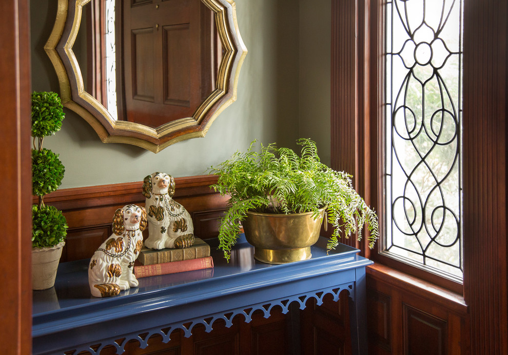 Imagen de vestíbulo tradicional pequeño con paredes verdes, suelo de madera en tonos medios y puerta simple