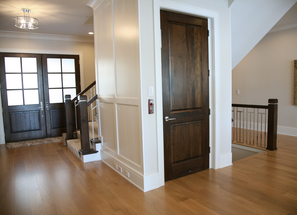 Immagine di una porta d'ingresso contemporanea di medie dimensioni con pareti beige, parquet chiaro, una porta a due ante, una porta in legno scuro e pavimento marrone