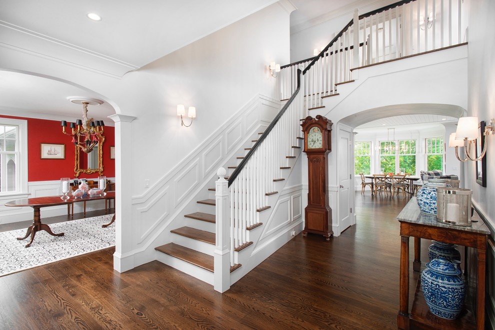 Medium sized classic foyer in New York with white walls, dark hardwood flooring and brown floors.