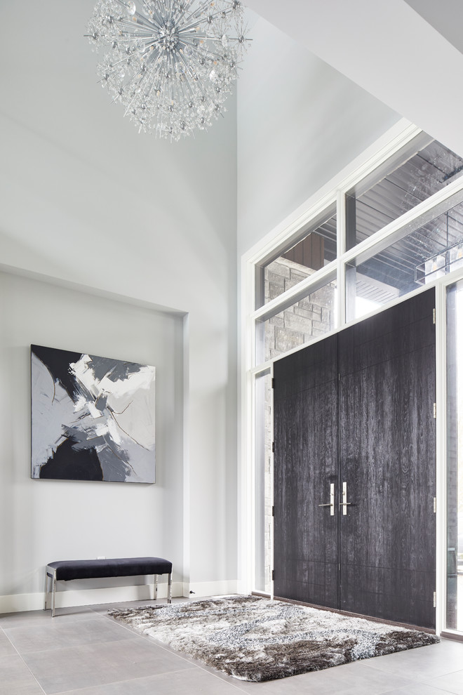 Inspiration pour un très grand hall d'entrée minimaliste avec un mur gris, un sol en ardoise, une porte double, une porte en bois foncé et un sol gris.