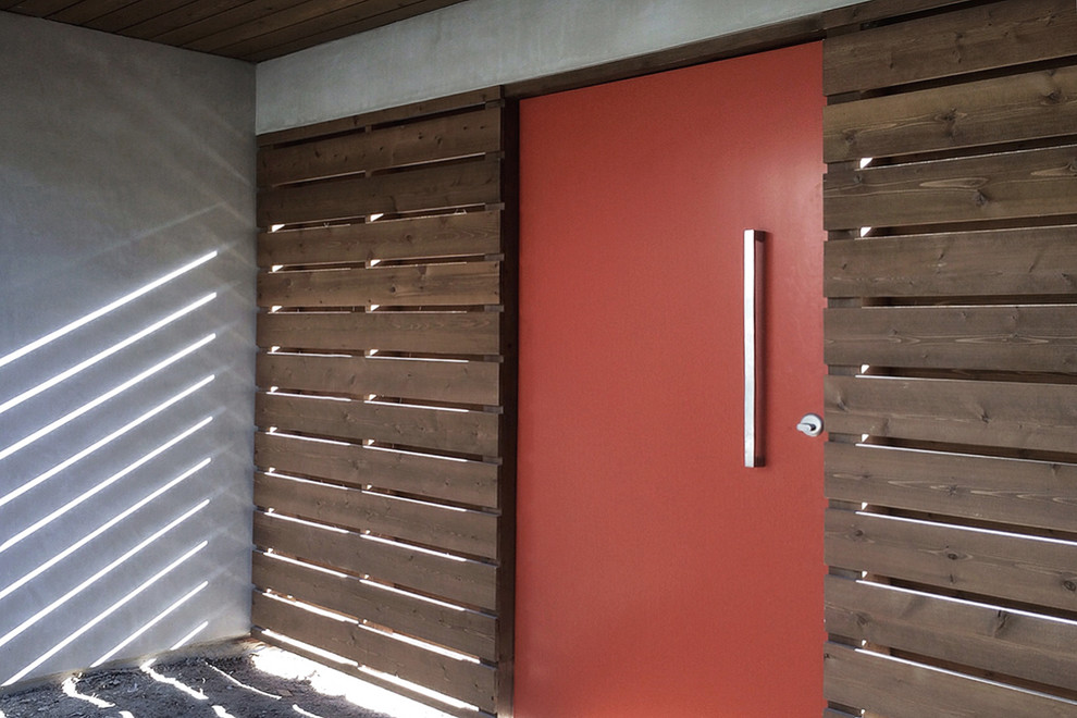 Foto de vestíbulo grande con puerta pivotante, puerta roja, paredes grises y madera