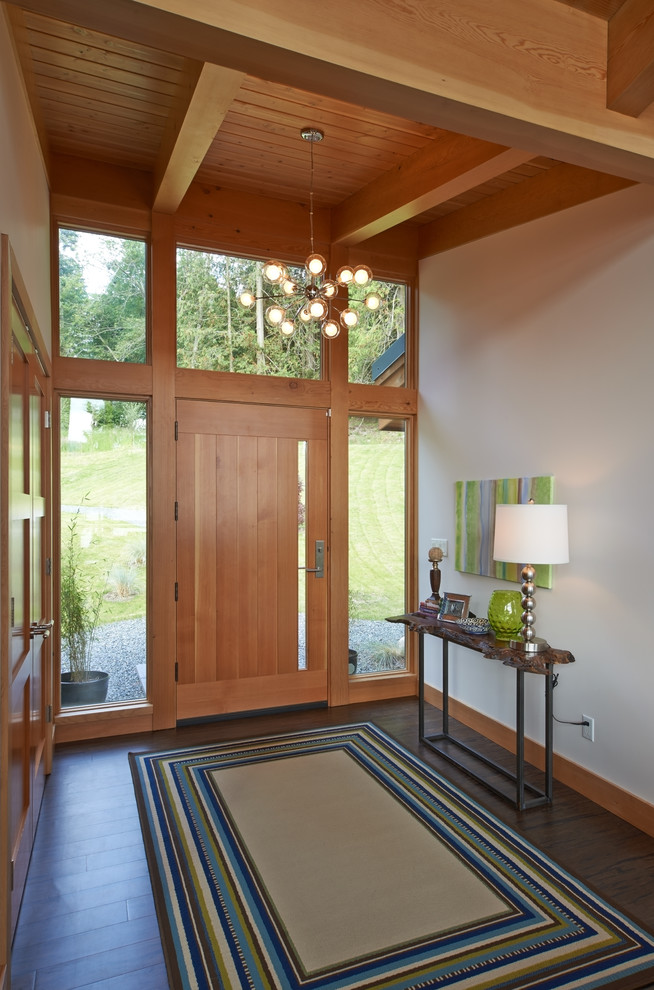 Idée de décoration pour un hall d'entrée chalet avec un mur blanc, parquet foncé, une porte simple et une porte en bois brun.