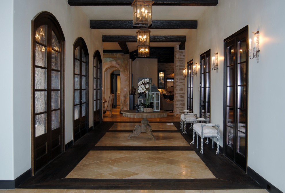Idée de décoration pour un grand hall d'entrée tradition avec un mur beige, un sol en marbre, une porte double et une porte en bois foncé.