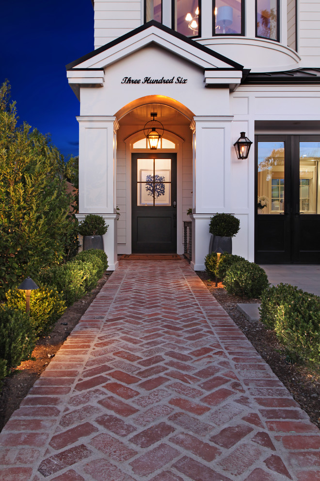 Entryway - traditional entryway idea in Orange County with white walls and a black front door