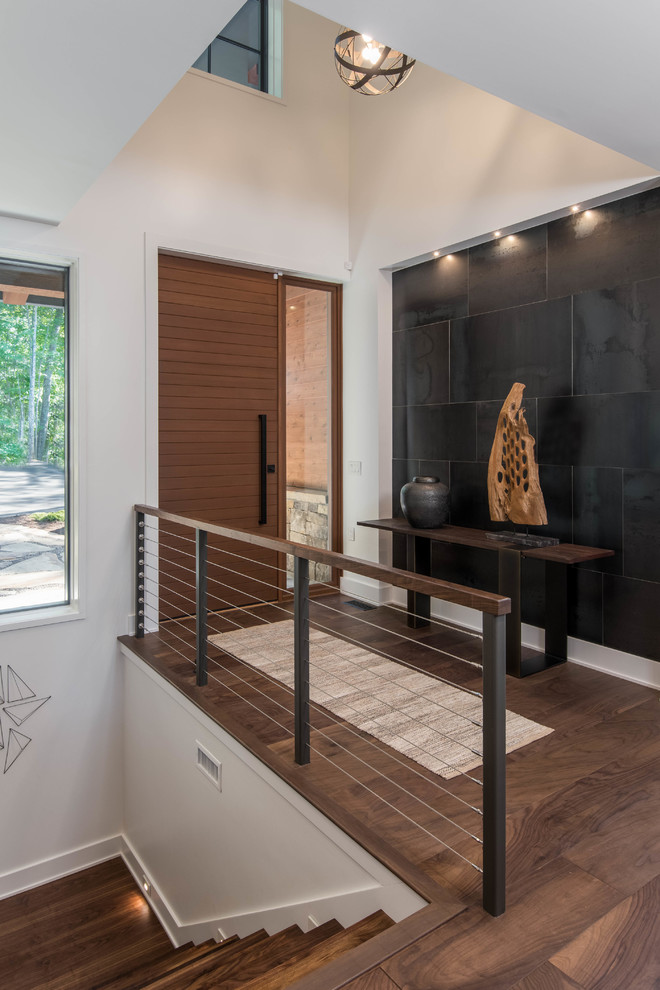 Cette photo montre une porte d'entrée montagne de taille moyenne avec un mur blanc, parquet foncé, une porte simple, une porte en bois foncé et un sol marron.