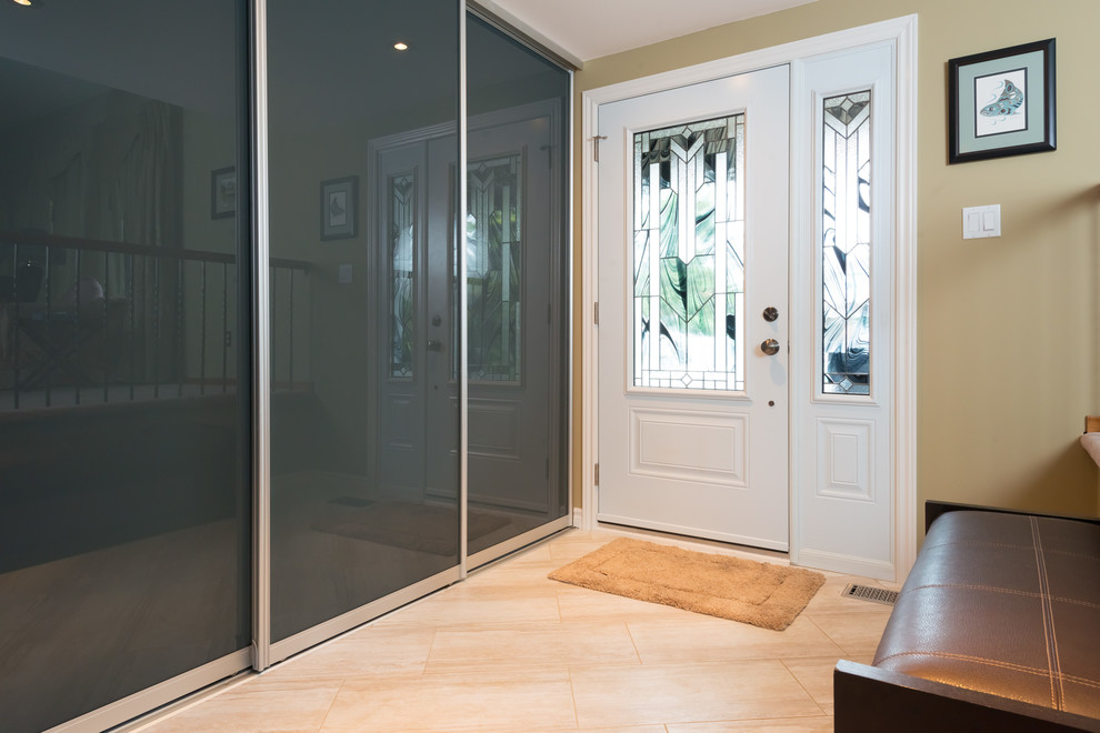 Idee per un ingresso contemporaneo di medie dimensioni con pareti beige, pavimento in travertino, una porta singola e una porta bianca