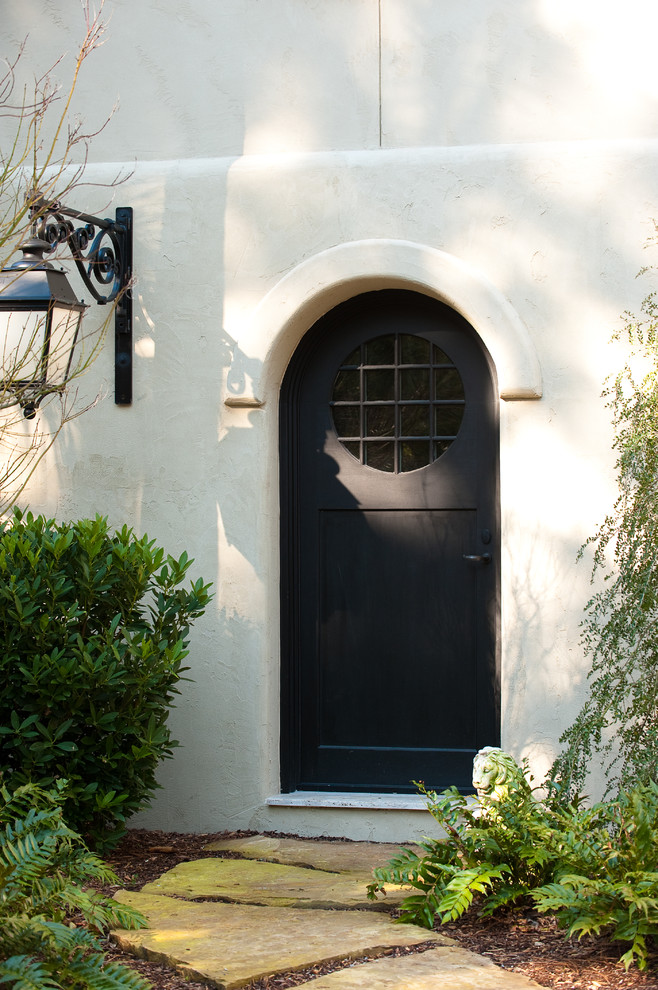 Esempio di un ingresso o corridoio tradizionale di medie dimensioni con una porta singola, una porta nera e pareti beige