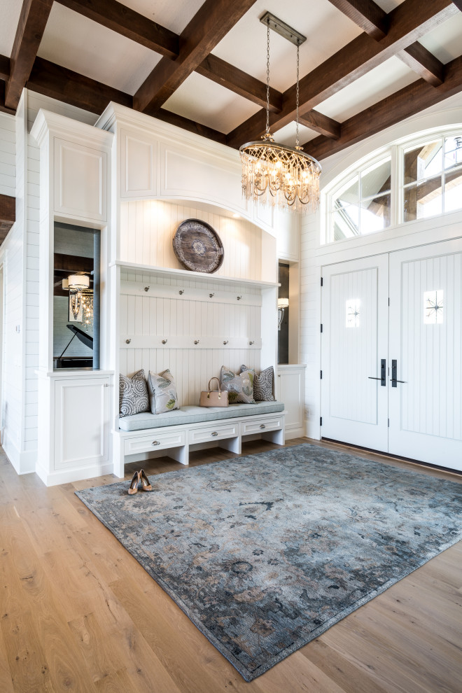 Ispirazione per un ingresso con anticamera chic con pareti bianche, pavimento in legno massello medio, una porta a due ante, una porta bianca e pavimento marrone