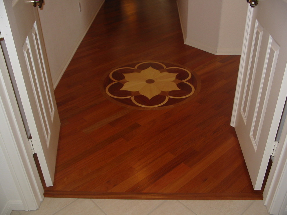 Example of a mid-sized tuscan medium tone wood floor entryway design in San Diego with beige walls and a white front door