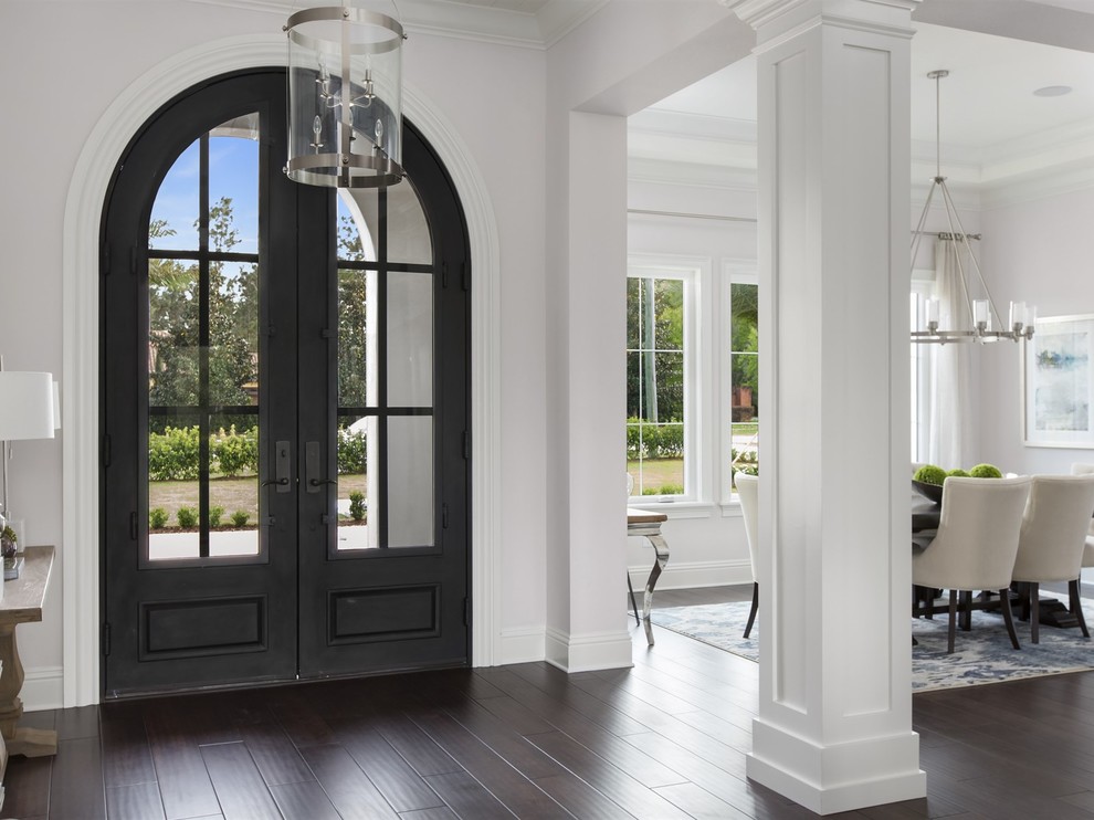 This is an example of a large mediterranean foyer in Orlando with grey walls, dark hardwood flooring, a double front door, a metal front door and feature lighting.