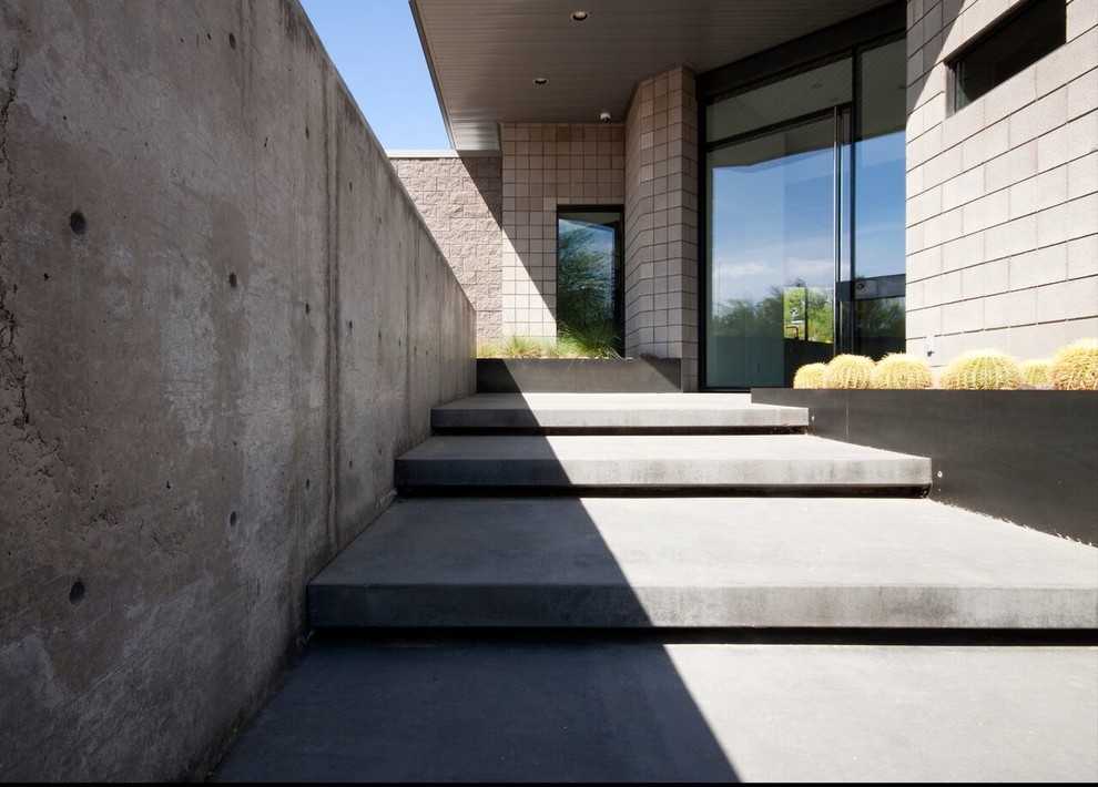 Inspiration for a large modern concrete floor entryway remodel in Phoenix with gray walls and a glass front door