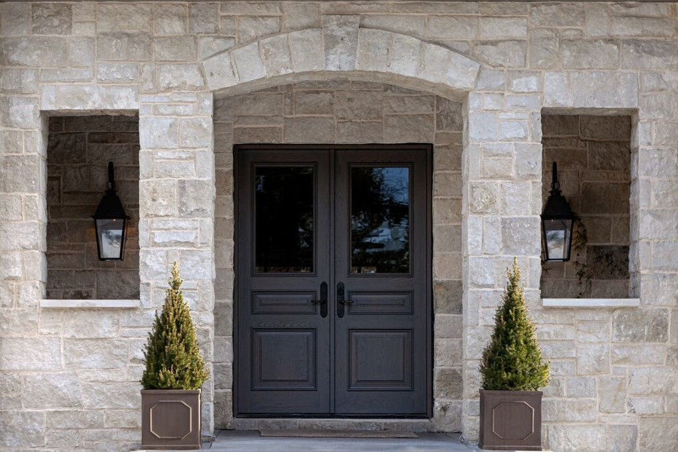 На фото: большая входная дверь в средиземноморском стиле с бетонным полом, двустворчатой входной дверью и черной входной дверью