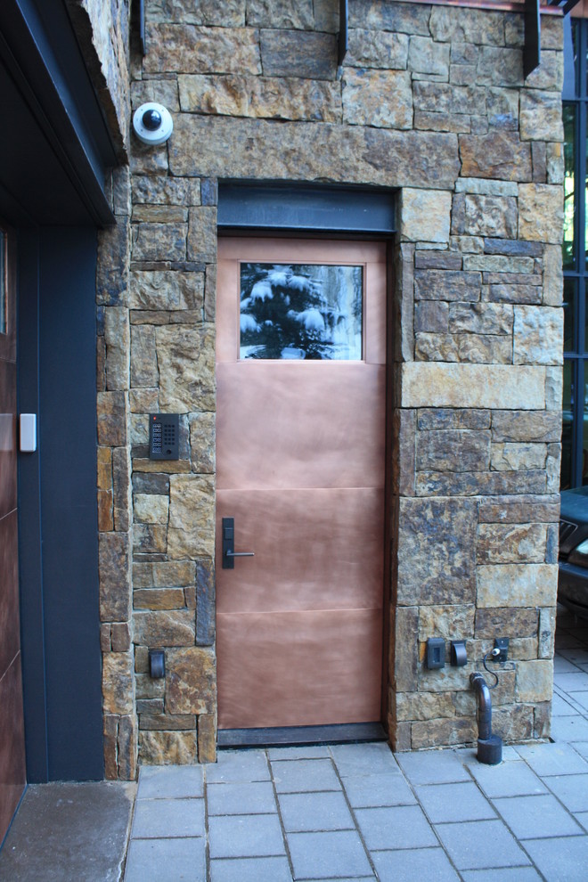 Cette image montre une petite entrée urbaine avec un vestiaire, un mur multicolore, une porte simple et une porte métallisée.