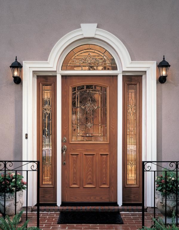 Cette photo montre une grande porte d'entrée chic avec un mur gris, un sol en brique, une porte simple et une porte en bois brun.