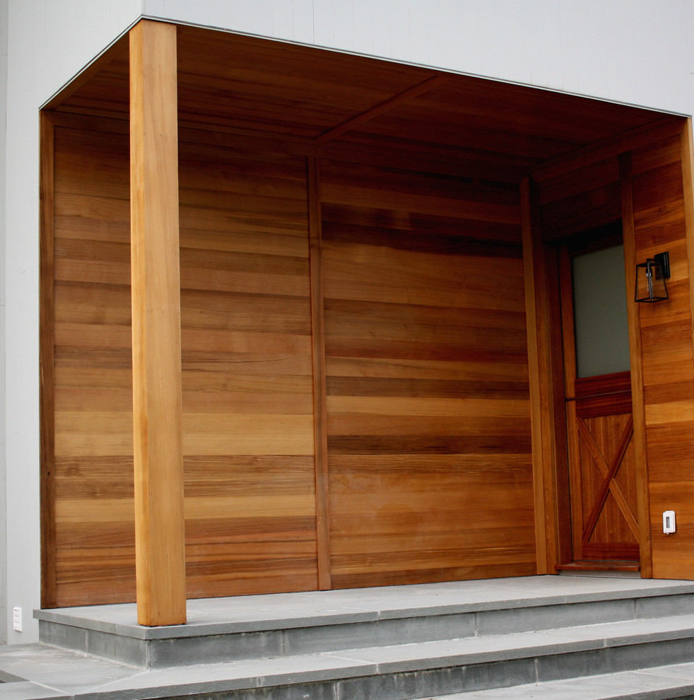 На фото: входная дверь среднего размера в современном стиле с бетонным полом, одностворчатой входной дверью, входной дверью из дерева среднего тона и серым полом