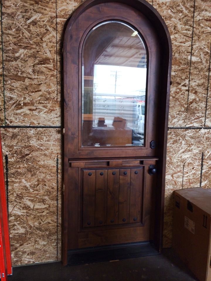 Immagine di una piccola porta d'ingresso mediterranea con parquet scuro, una porta olandese e una porta in legno scuro