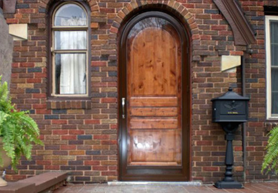 Immagine di una piccola porta d'ingresso tradizionale con una porta a pivot e una porta in legno bruno