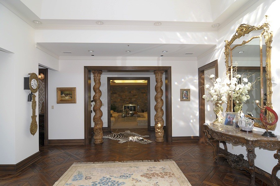 Photo of a large classic foyer in DC Metro with white walls, dark hardwood flooring and brown floors.