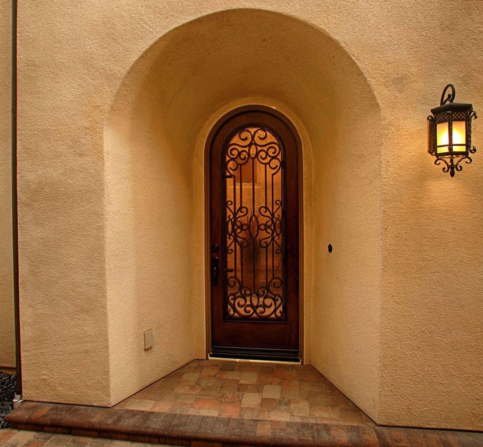 Cette image montre une porte d'entrée méditerranéenne de taille moyenne avec une porte simple et une porte en bois brun.